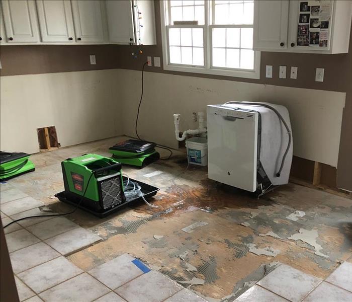 drying equipment working in a floor and wall damaged kitchen